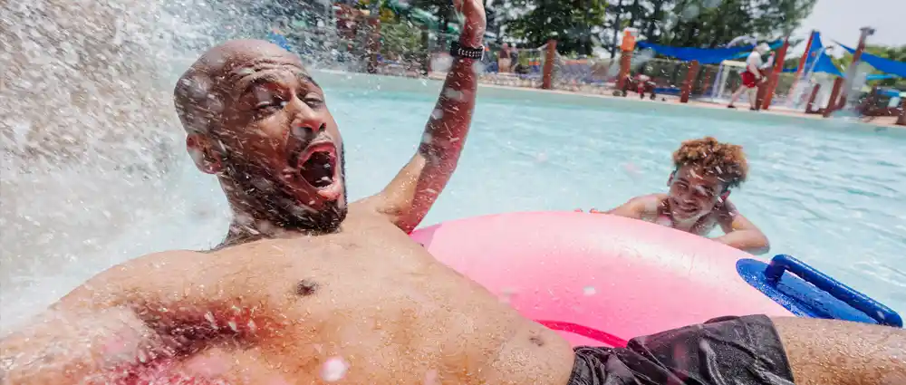 Son splashing his Dad in the wave pool